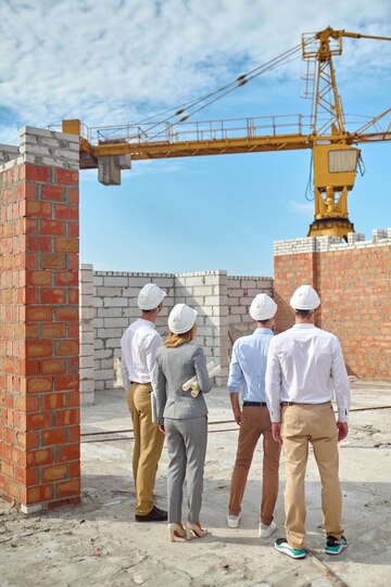 Workers in helmets inspecting a building site Workers in helmets inspecting a building site